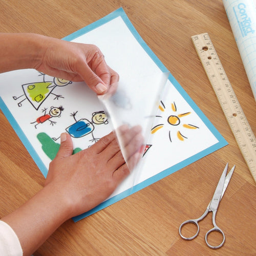 Close-up of someone covering a child’s drawing with a matte finish Clear Cover™